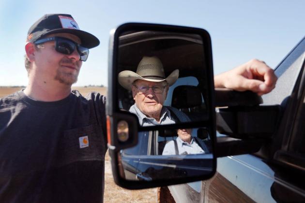 Tanner Heffington, left, talks to Jimmy Drake. Drake, 86, last year decided to retire after farming for seven decades. Heffington, 31, is taking over the farm. Photo by Mark Rogers for The Texas Tribune