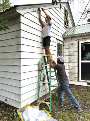 Pictured here are volunteers hard at working getting the siding ready to paint. Photo courtesy of Corina Fauley